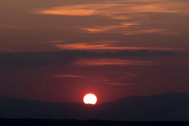 the sun is setting over the mountains in the distance, by Attila Meszlenyi, pexels contest winner, big red sun, new hampshire, 2 0 0 mm wide shot, summer setting