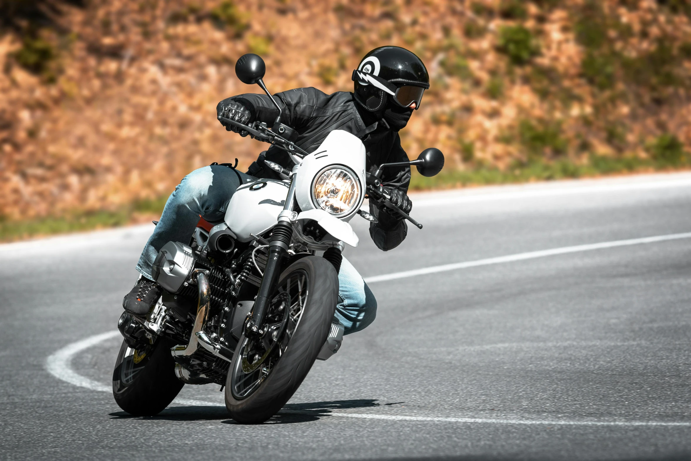 a man riding a motorcycle down a curvy road, profile image, triumph, rebel, white