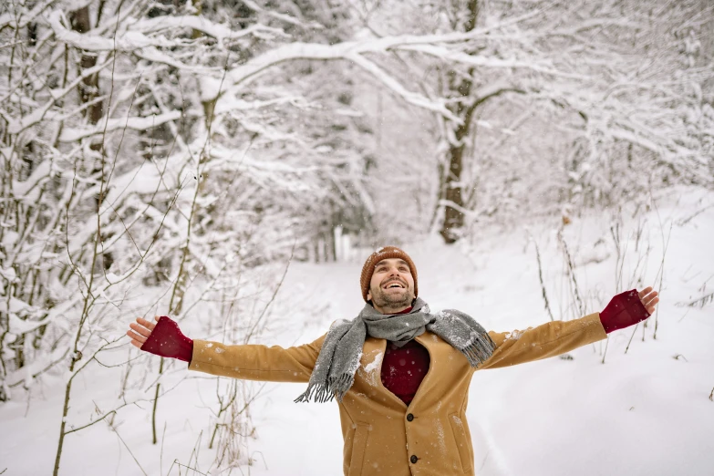 a man in the snow has his arms out in the air