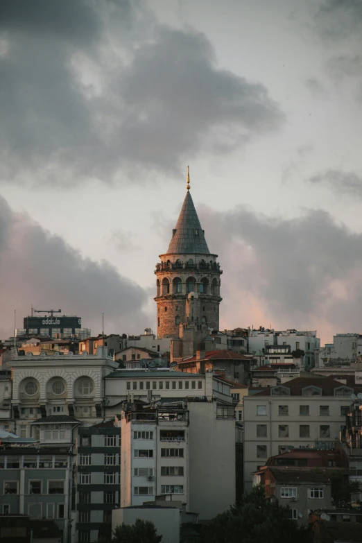 a very tall clock tower towering over a city, inspired by Niyazi Selimoglu, unsplash contest winner, tiled roofs, overcast dusk, ottoman sultan, spiraling