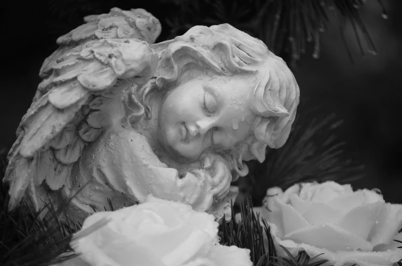 a black and white photo of a statue of an angel, pixabay, romanticism, laying on roses, child, high details photo