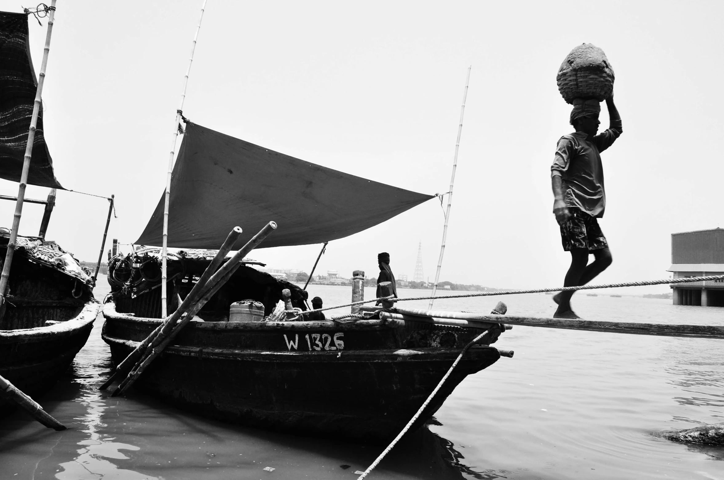 a black and white photo of two boats in the water, by Sudip Roy, dada, fish man, she is walking on a river, sense of scale, boat with lamp