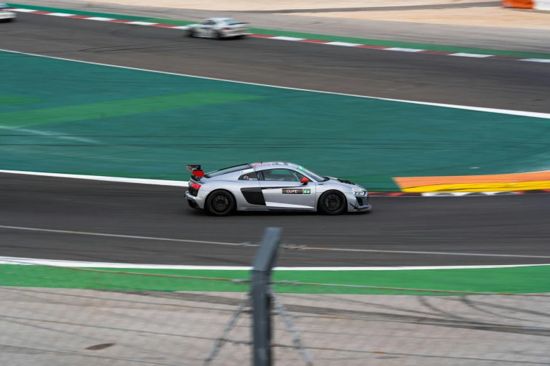 a white car driving along a race track