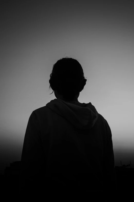 a person that is standing in the dark, a black and white photo, gazing off into the horizon, profile image, album cover, faceless people
