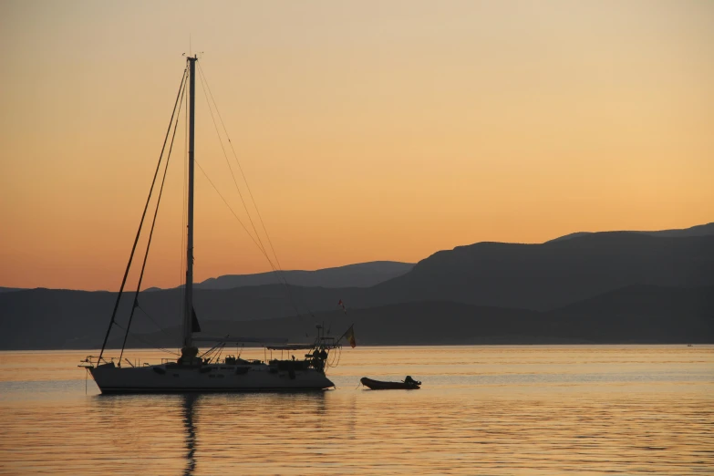 a boat floating on top of a large body of water, inspired by Edwin Georgi, pexels contest winner, romanticism, pastel orange sunset, greek nose, three masts, skye meaker