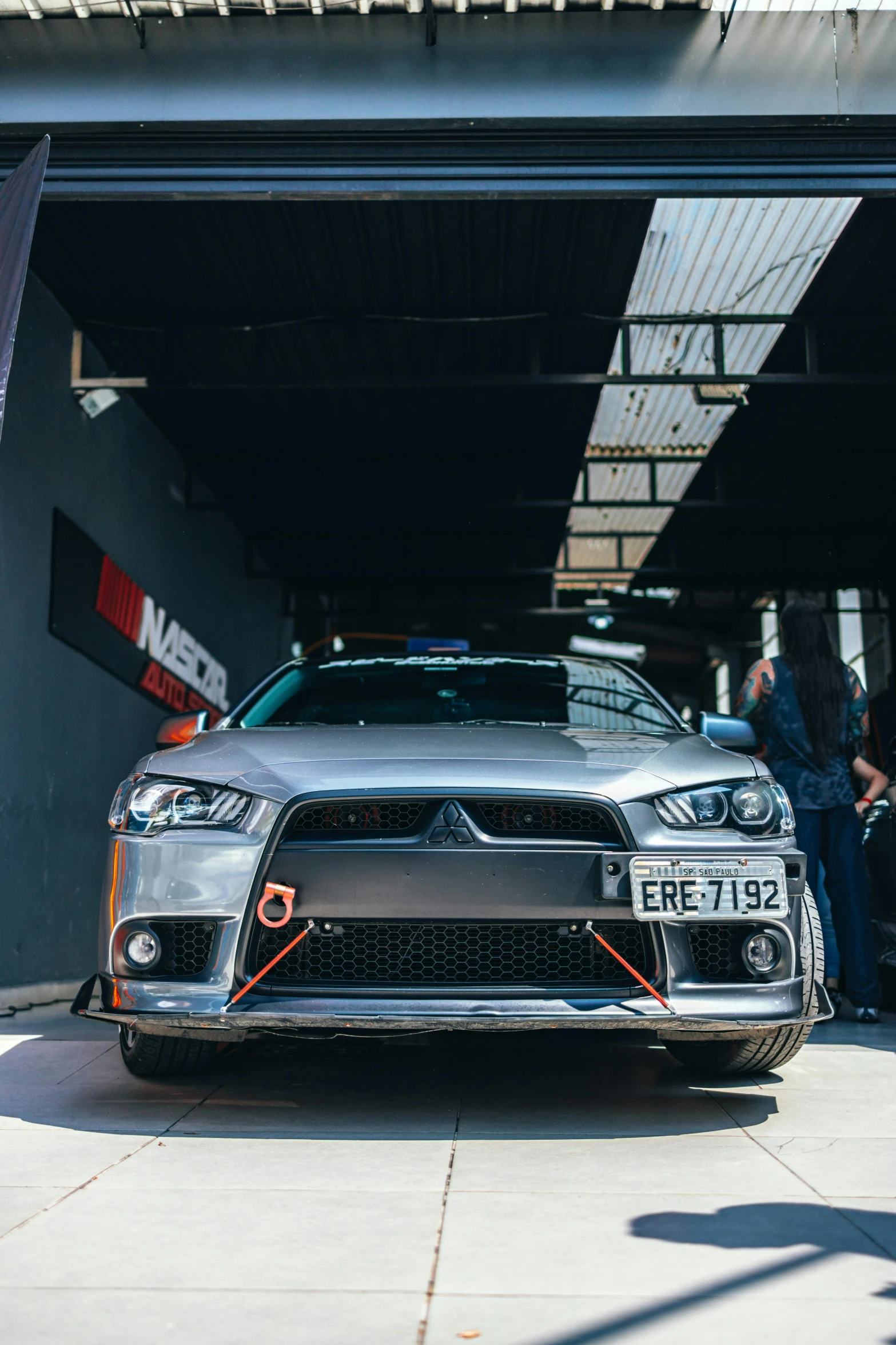 a sports car in a garage with other people