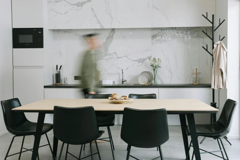 a man is walking past a table and chairs