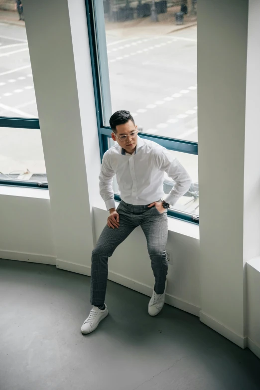 a man leaning against a window with his hands on his hips, inspired by Victor Wang, happening, wearing business casual dress, darren quach, a high angle shot, on a white table