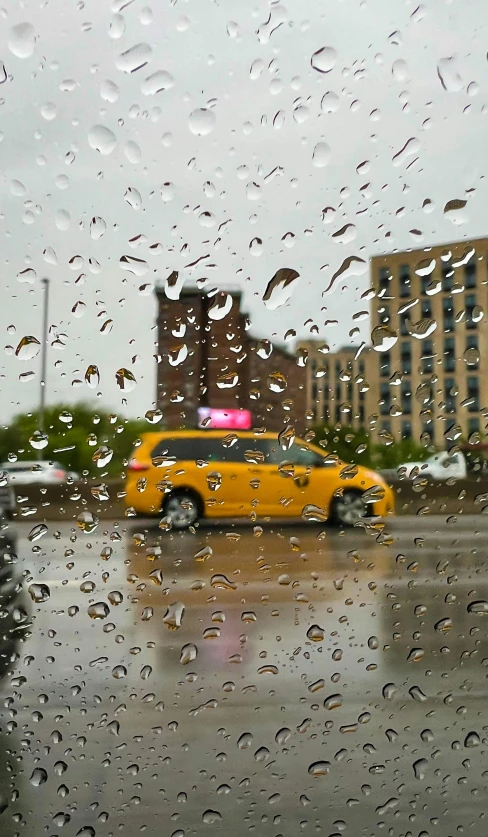 a yellow taxi cab driving down a wet street, by Josh Bayer, joel sternfeld, square, low quality photo