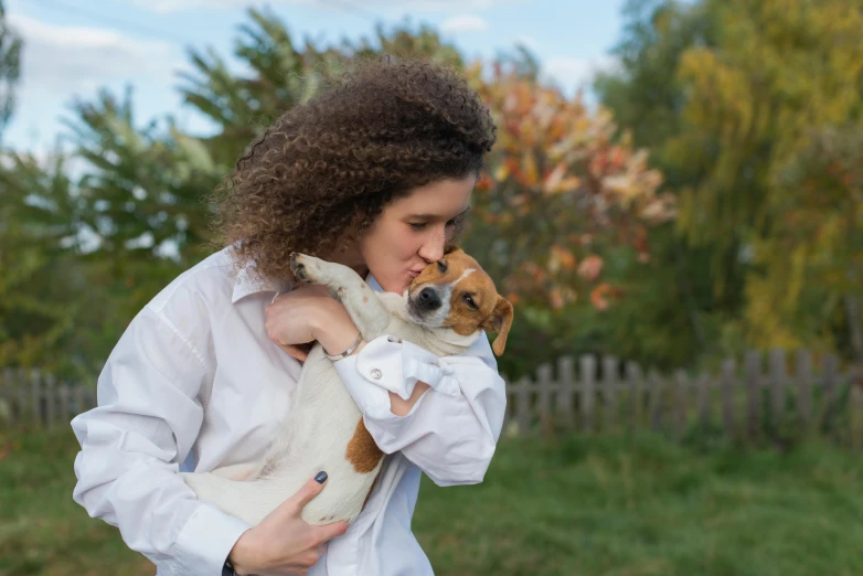 a woman holding a small dog in her arms, by Julia Pishtar, pexels contest winner, jack russel terrier, 15081959 21121991 01012000 4k, autum, cute beagle