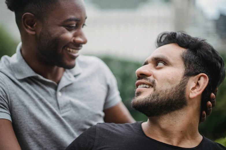 a couple of men standing next to each other, trending on pexels, smiling at each other, mixed race, avatar image, lgbt