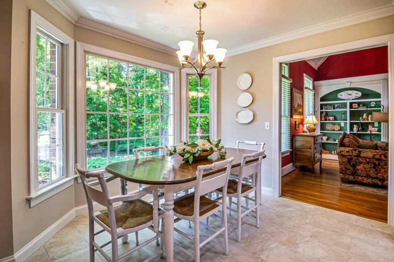 a dining room table with six chairs and a vase of flowers