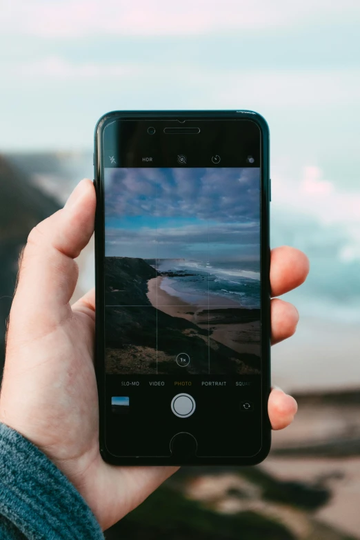 a person taking a picture with their cell phone, pexels contest winner, realism, ocean in the background, rule for thirds, fan favorite, slightly pixelated