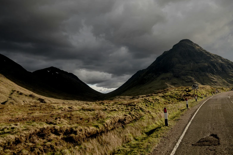 a van is driving down a road between mountains