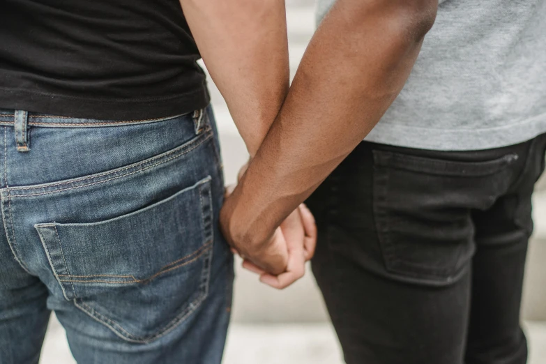 a close up of two people holding hands