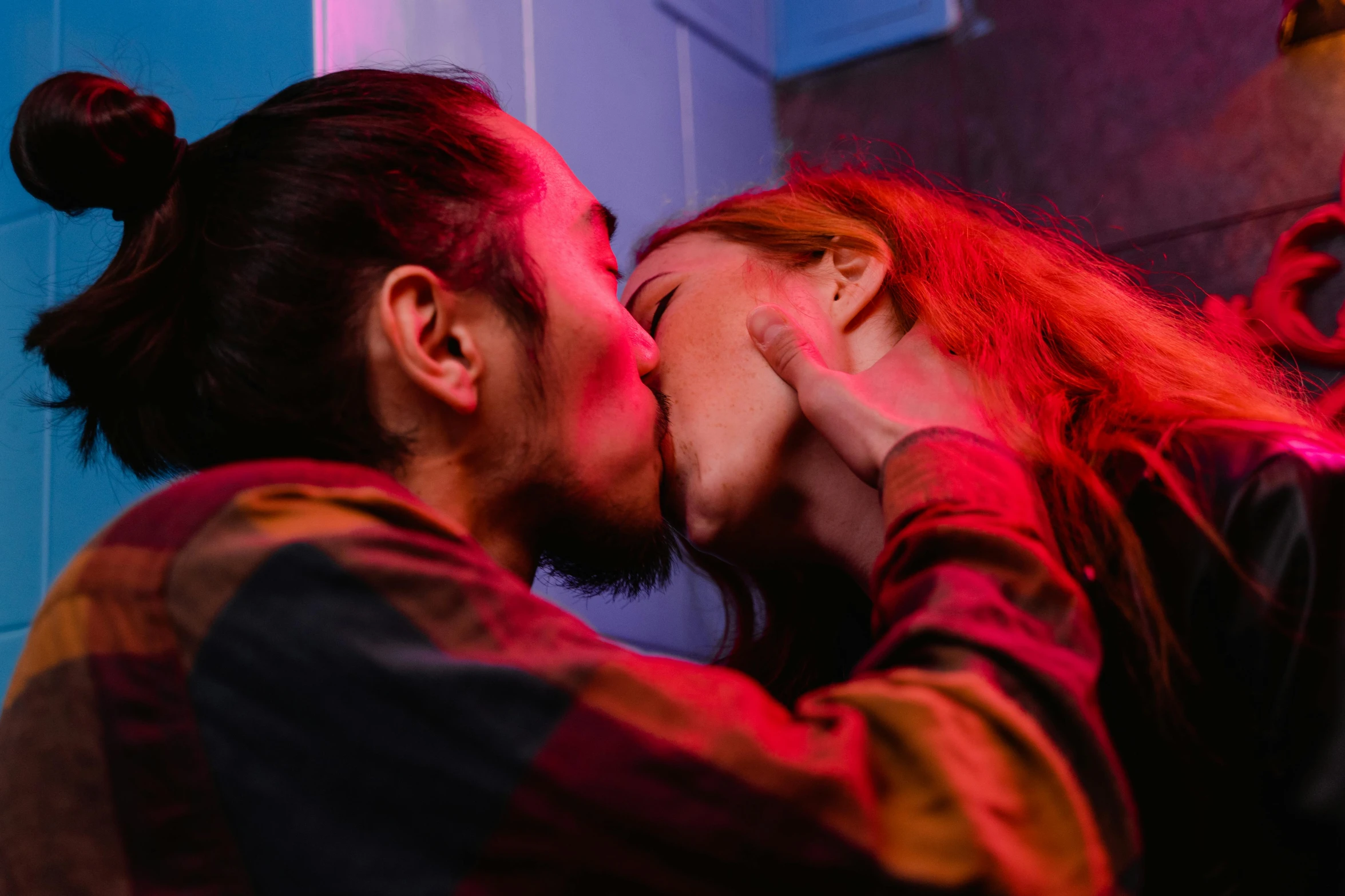 a couple of people that are kissing each other, inspired by Nan Goldin, trending on pexels, multicoloured, asian man, cyberpunk strip clubs, ( redhead