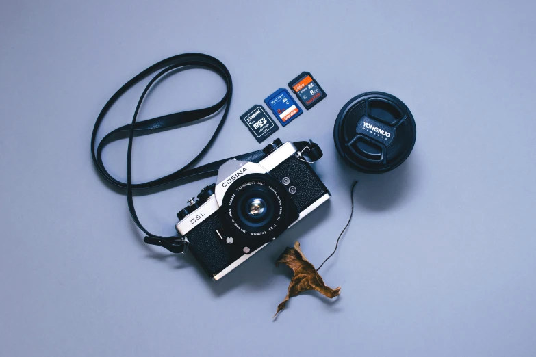 a camera sitting on top of a table next to a memory card, by Adam Rex, art photography, film artifacts, flatlay, konica minolta, ((sharp focus))