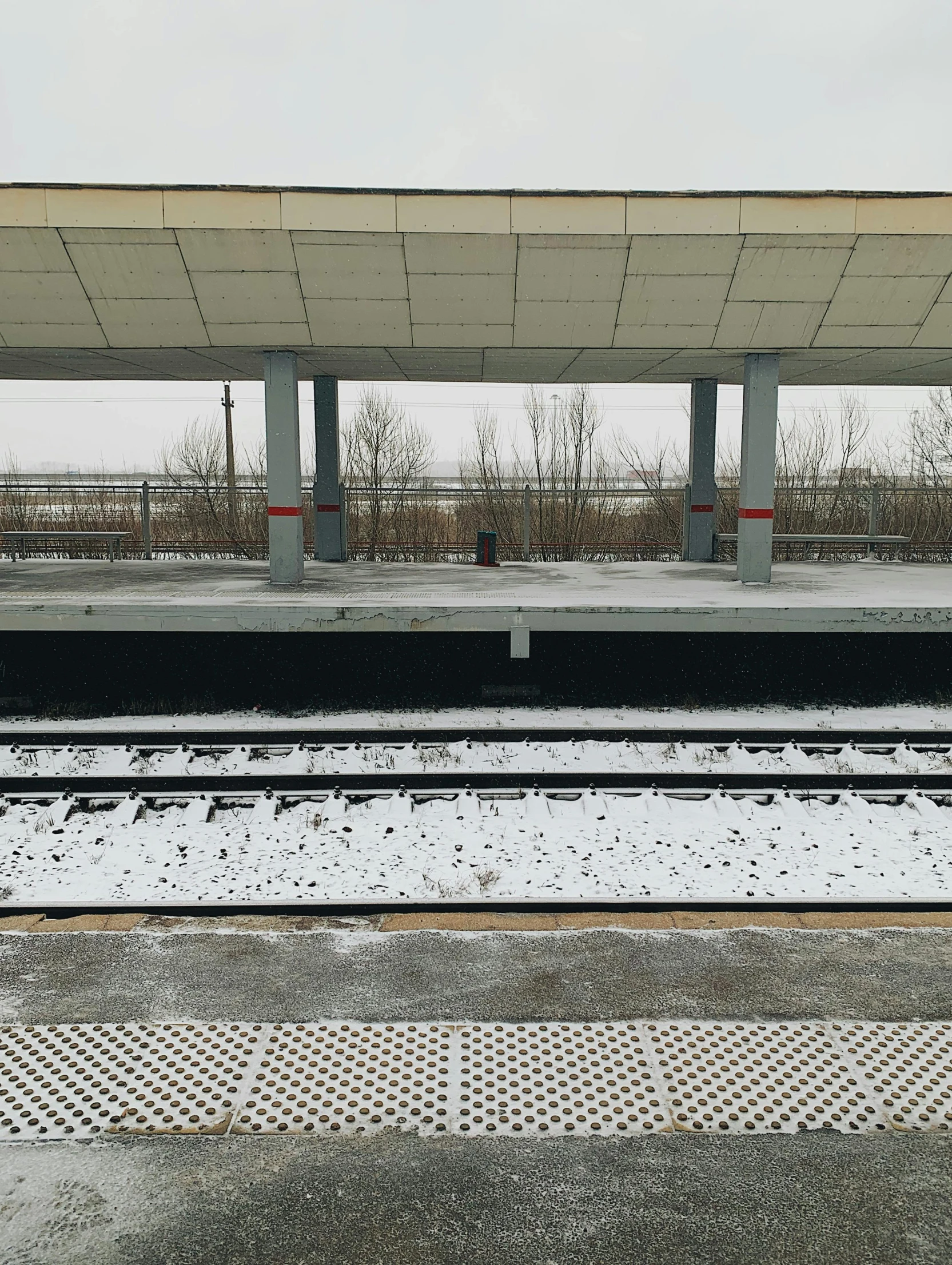 a train track under an overpass on a cloudy day