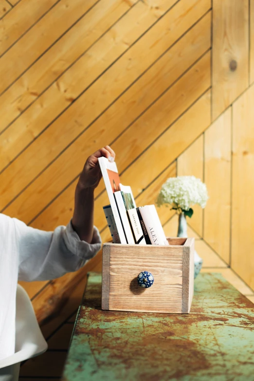 a man that is holding some books in a box