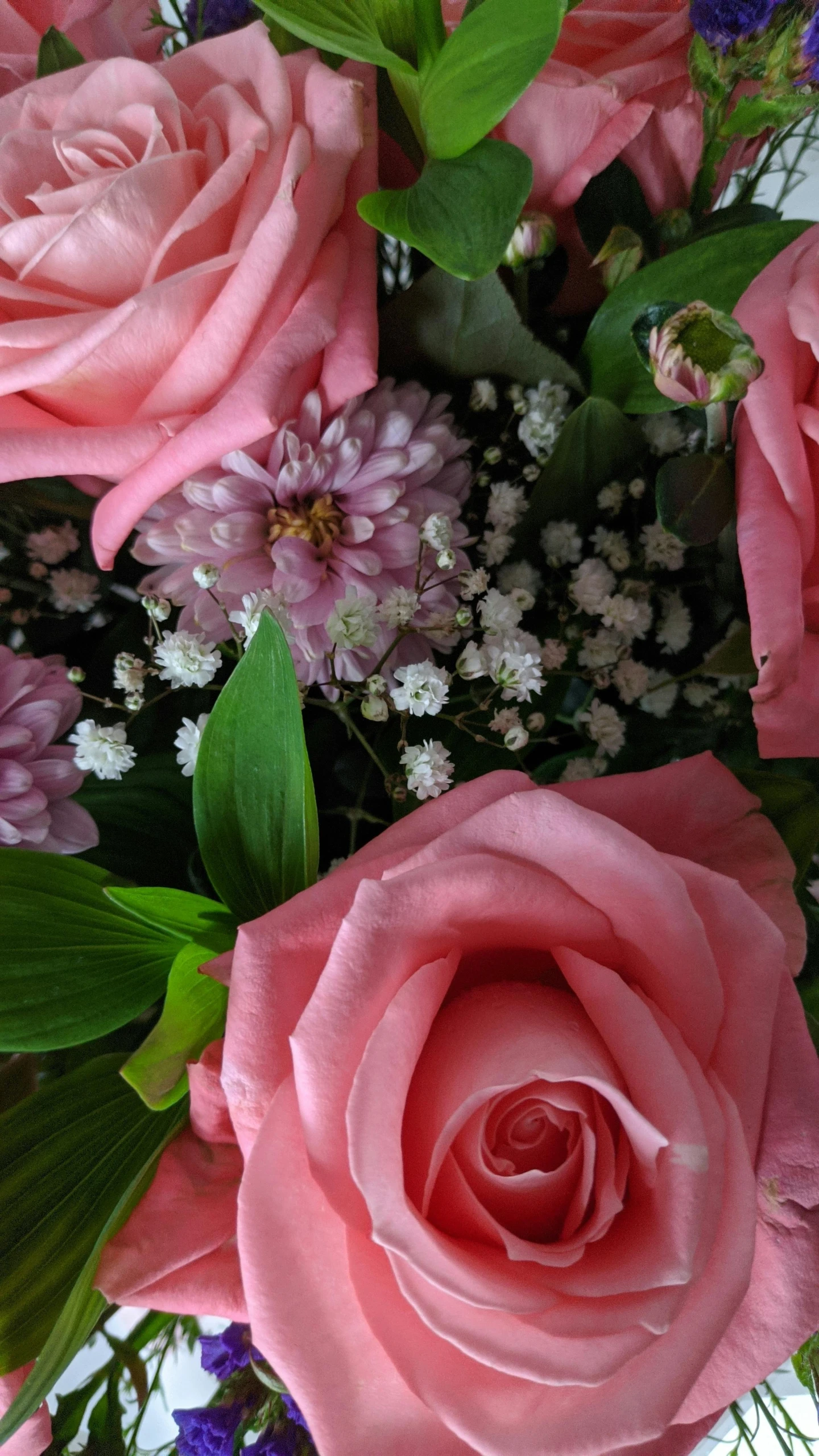 the flower arrangement is surrounded by pink flowers