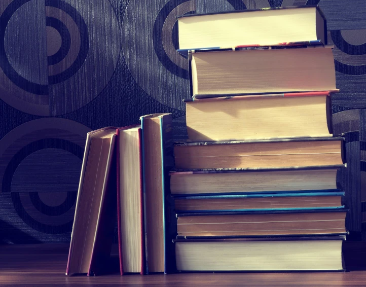 a stack of books sitting on top of a wooden table