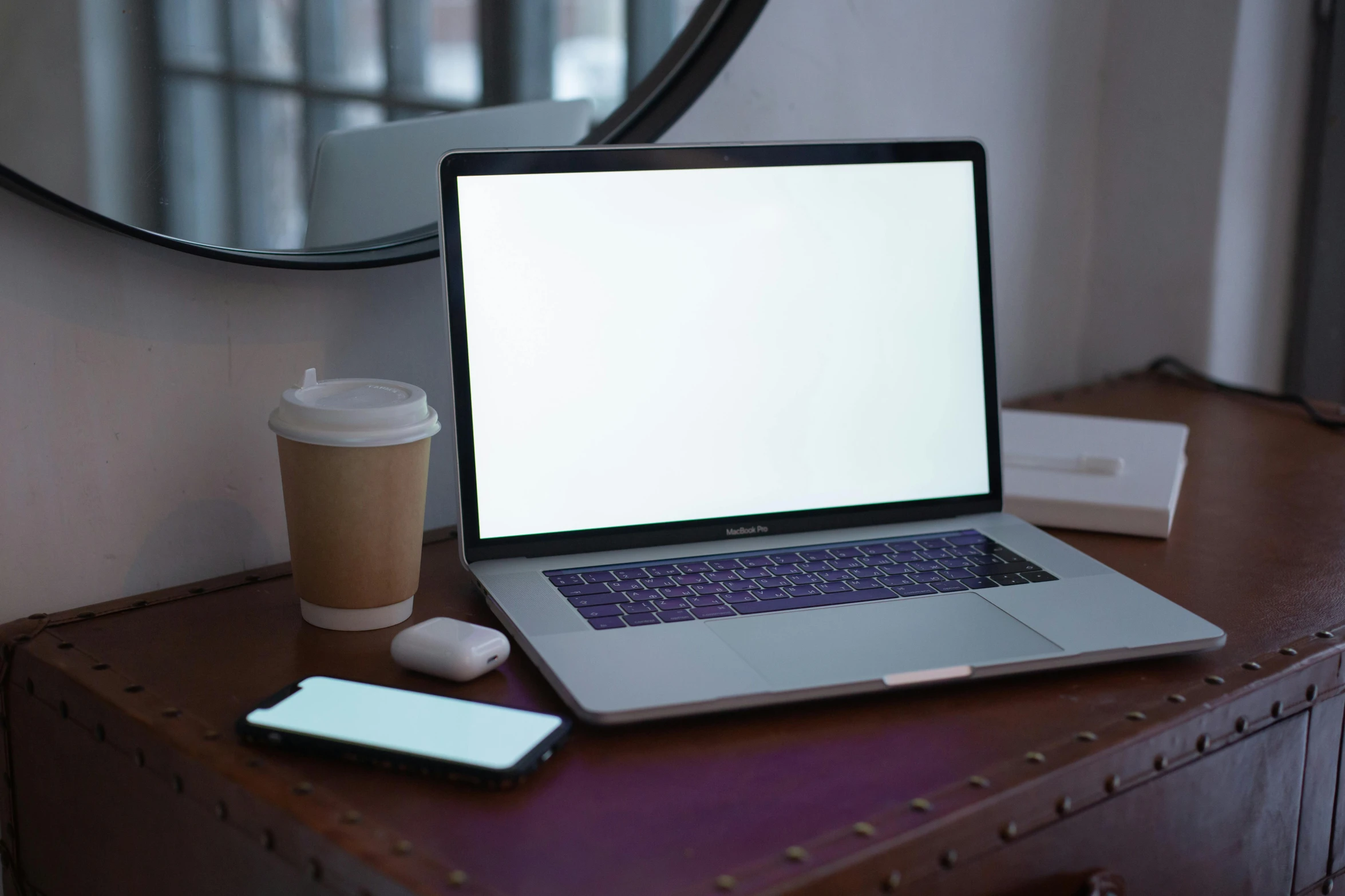 a laptop computer sitting on top of a wooden desk, by Carey Morris, pexels, sitting on a mocha-colored table, white, glowing screen, where a large