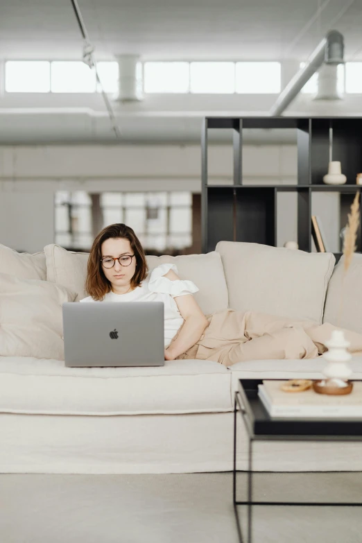 a woman sitting on a couch using a laptop, trending on pexels, developers, low quality photo, caucasian, student