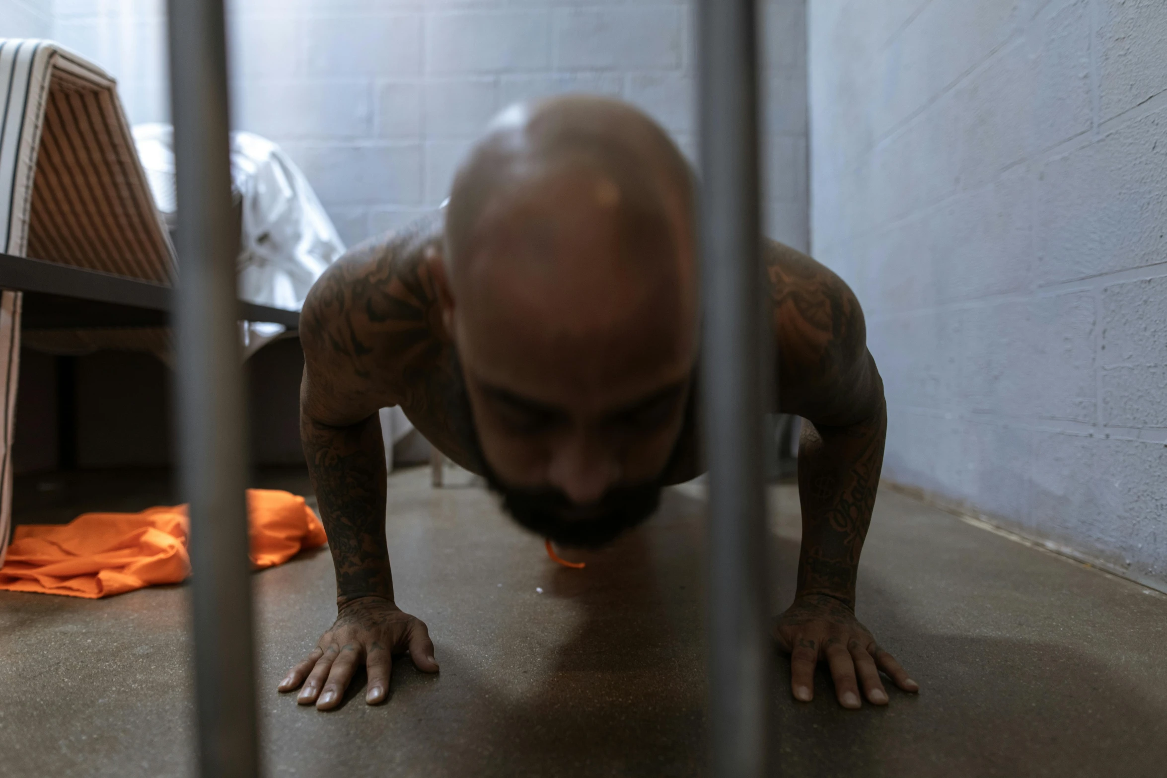 a man doing push ups in a jail cell, a tattoo, ariel perez, profile image