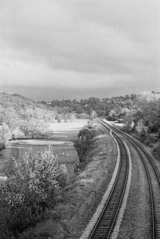 a drawing of railroad tracks in the foreground and hills in the background