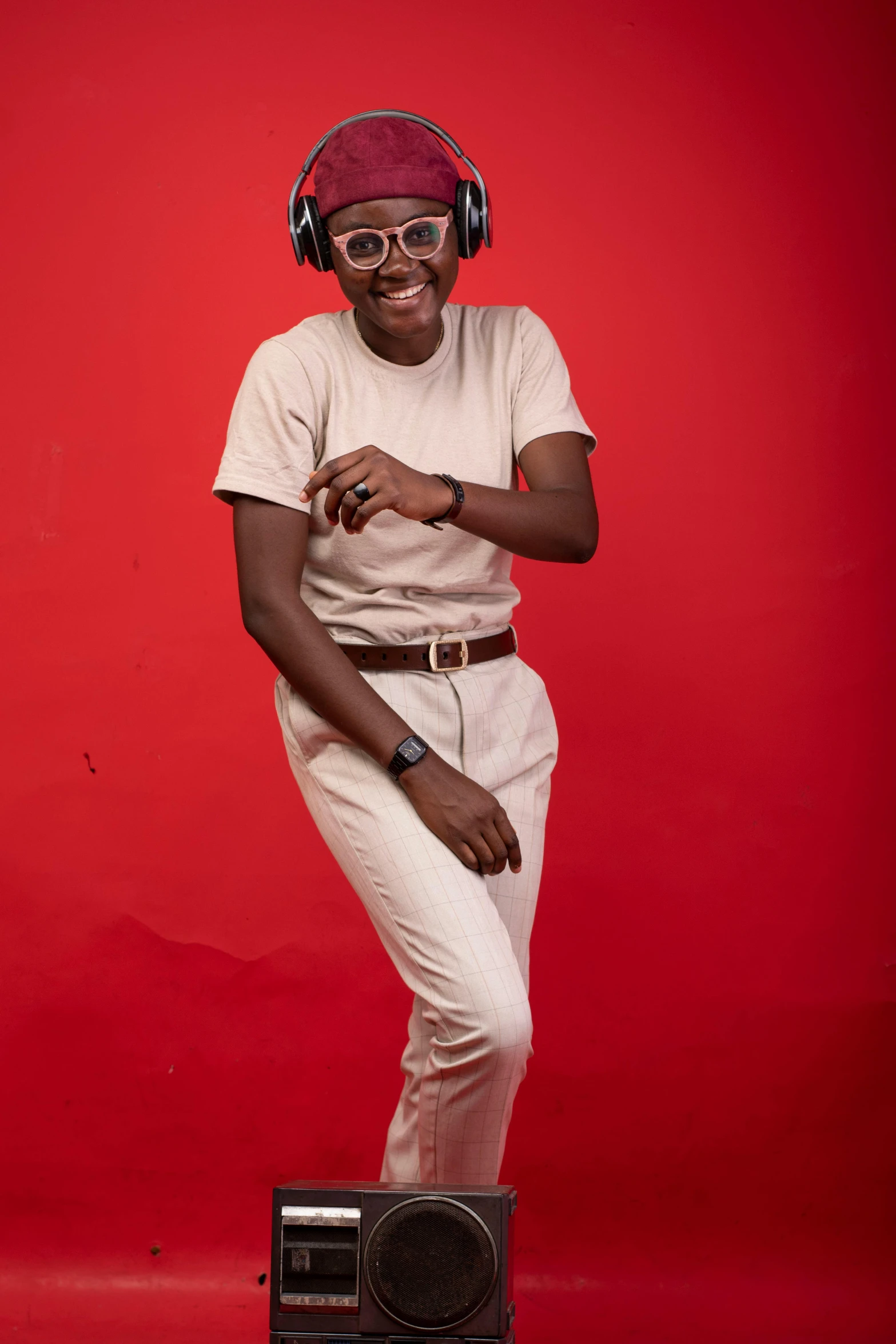 a man standing on top of a boombox wearing headphones, by Chinwe Chukwuogo-Roy, trending on pexels, studio portrait photo, brown:-2, androgynous, all red