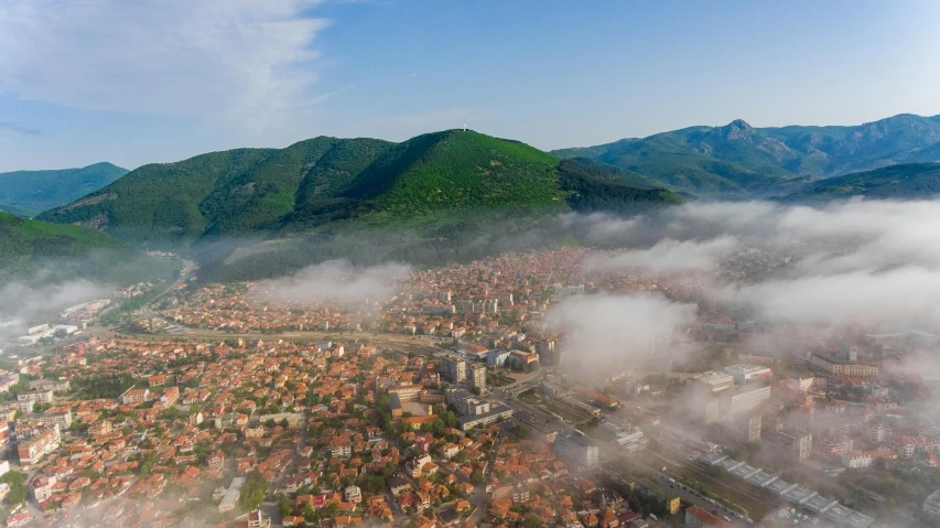 a small city nestled in some mountains with fog