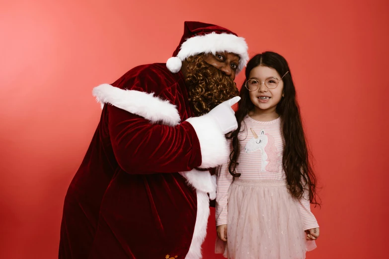 the girl poses next to the santa clause costume
