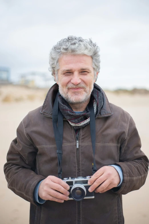 a man standing with his camera on the beach