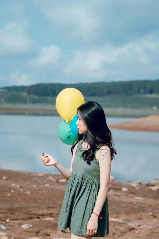 a woman wearing a dress and holding balloons