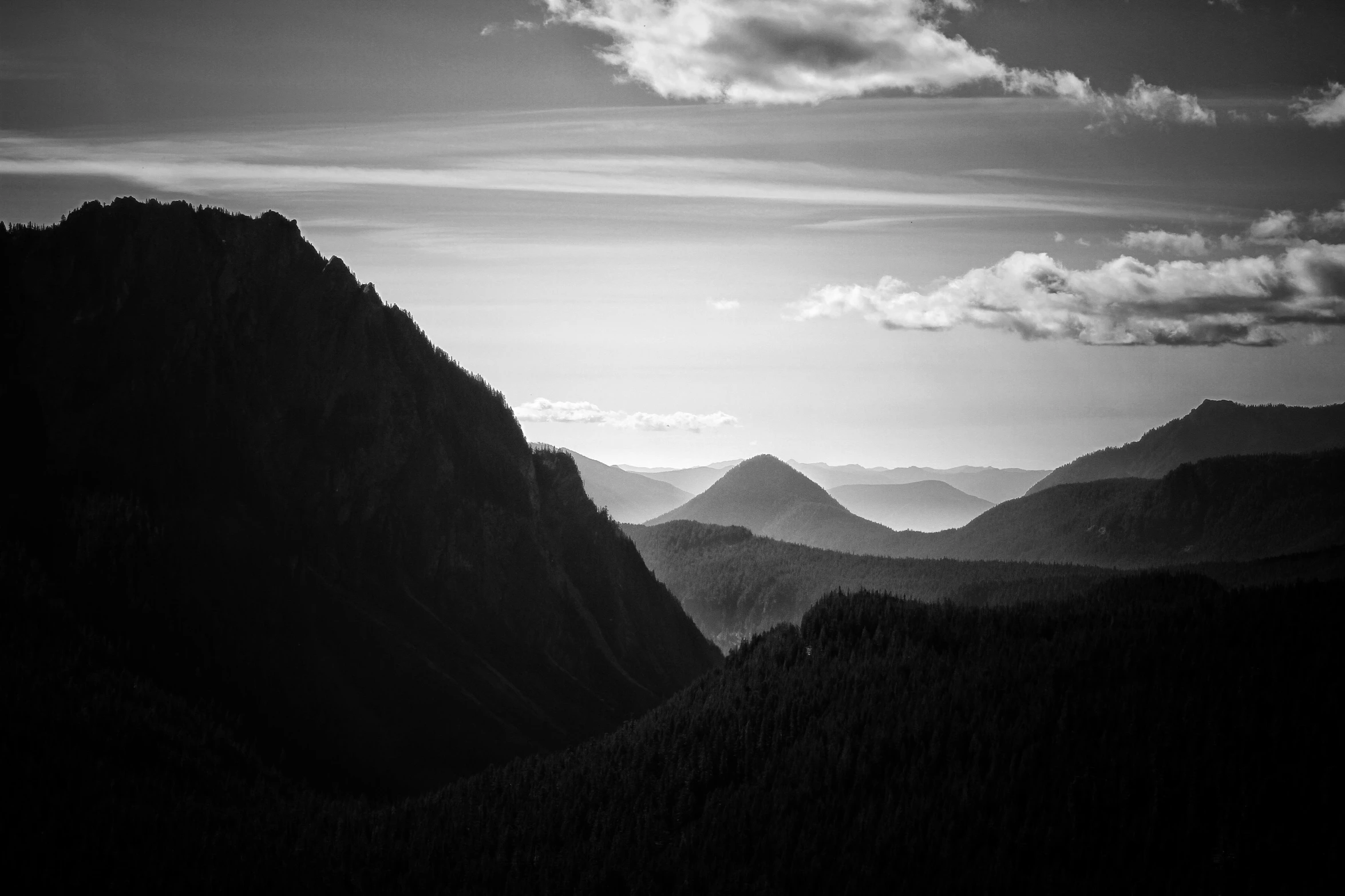 a black and white photo of a mountain range, by Matthias Weischer, unsplash contest winner, cascadia, horizon forbideen west, afternoon sunlight, high view