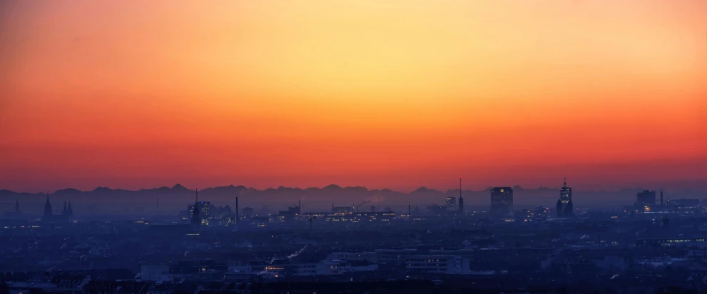 a view of a city at sunset from the top of a hill, pexels contest winner, romanticism, industrial colours, hannover, heat haze, plain background