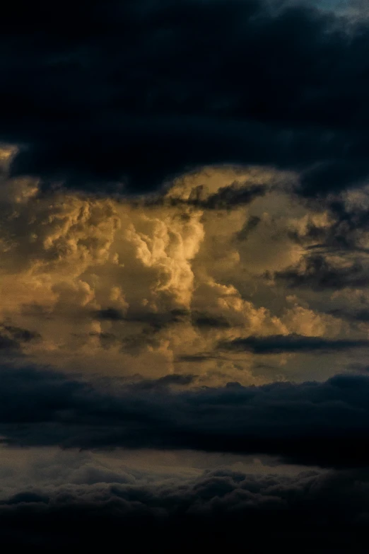 an airplane flying in the sky under dark clouds