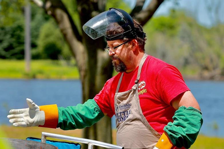 a man that is standing in front of a grill, welding helmet head, renaissance fair, fishing, wearing plumber uniform