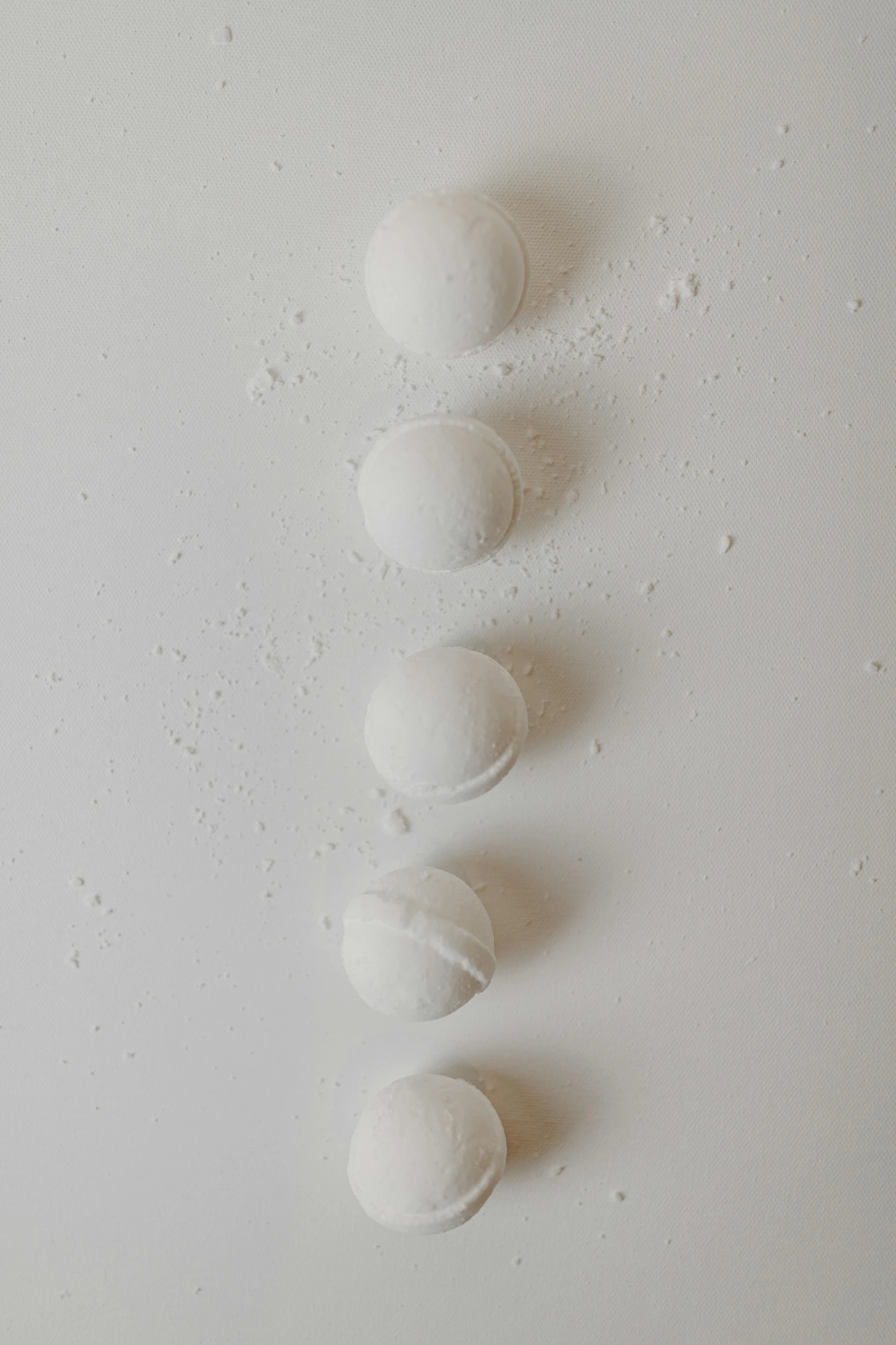 a group of white balls sitting on top of a white surface, inspired by Agnes Martin, unsplash, covered in white flour, 3/4 view from below, candy treatments, kiss