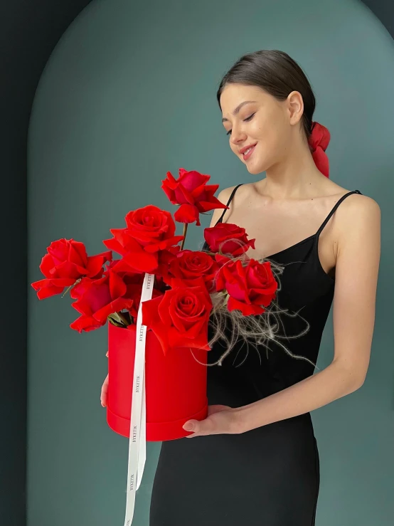 a woman in a black dress holds flowers