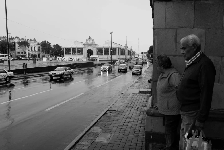 an older couple looking out the window on a rainy day