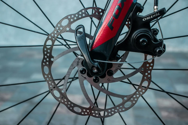 a close up of a bicycle's front brake, pexels contest winner, red and black robotic parts, instagram post, detailed product image, high quality product image”