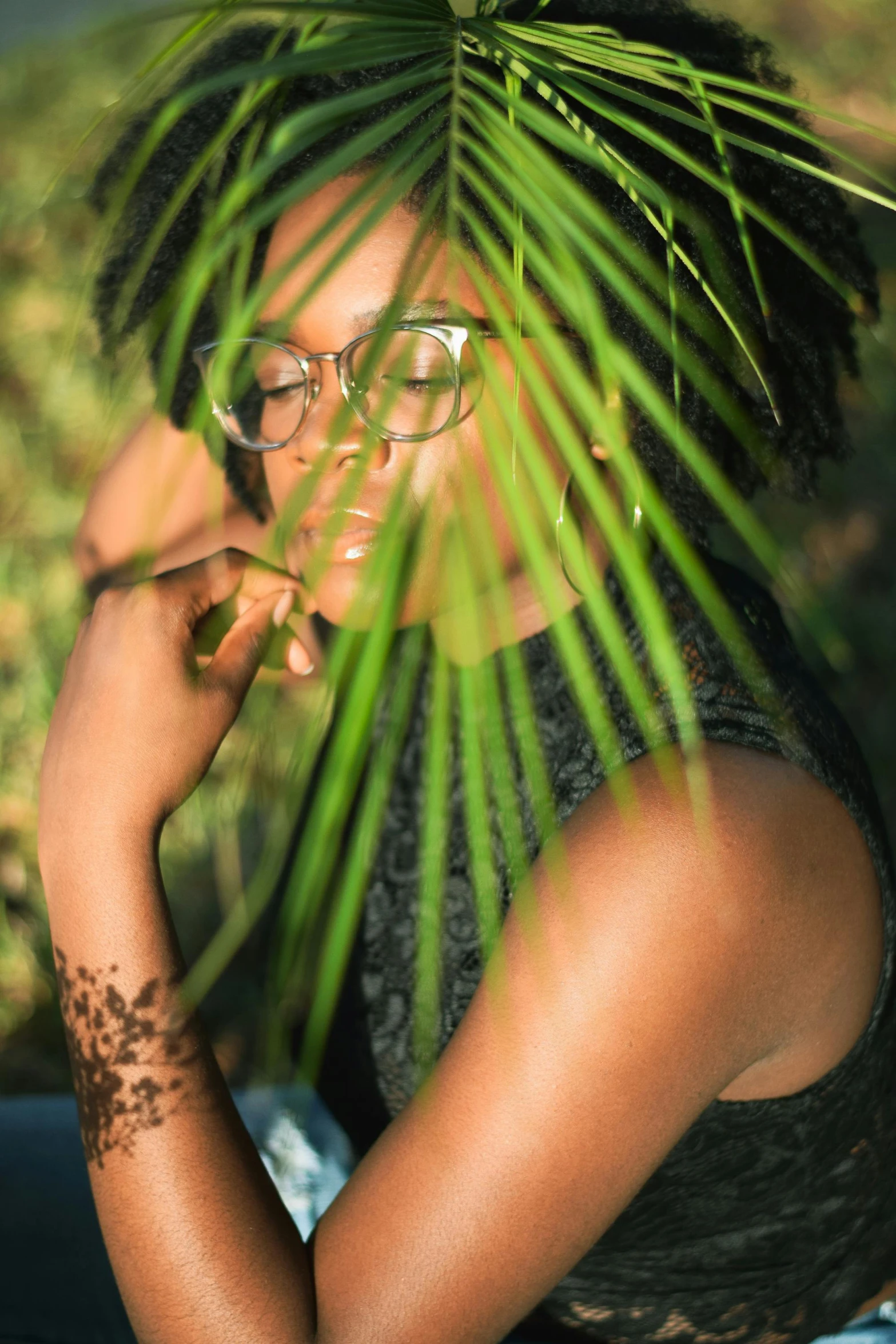 a woman with a palm leaf on her head, an album cover, by Stokely Webster, pexels contest winner, plants in glasses, ( ( dark skin ) ), natural sensuality, in a tree