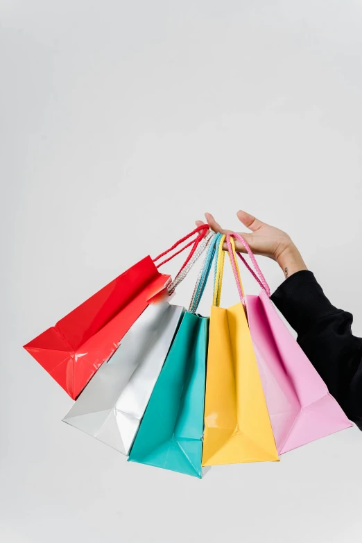 a woman holding colorful bags in the air