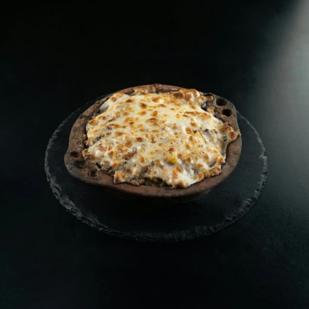 a pizza sitting on top of a black plate, detailed product image, chocolate river, frontal shot, (cheese)