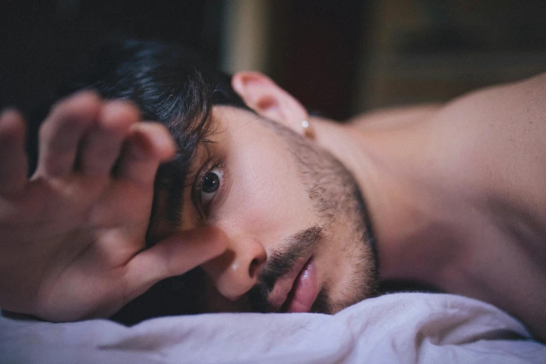 a close up of a person laying in a bed, by Adam Dario Keel, looking confused, attractive pose, third eye in middle of forehead, looking seductive