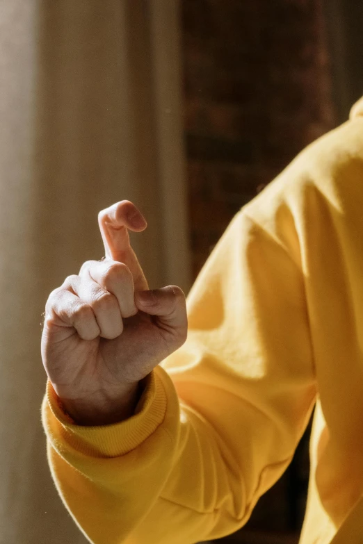 a man in a yellow shirt holding a nintendo wii controller, unsplash, precisionism, giving the middle finger, yellow robes, heavy gesture style closeup, instagram post