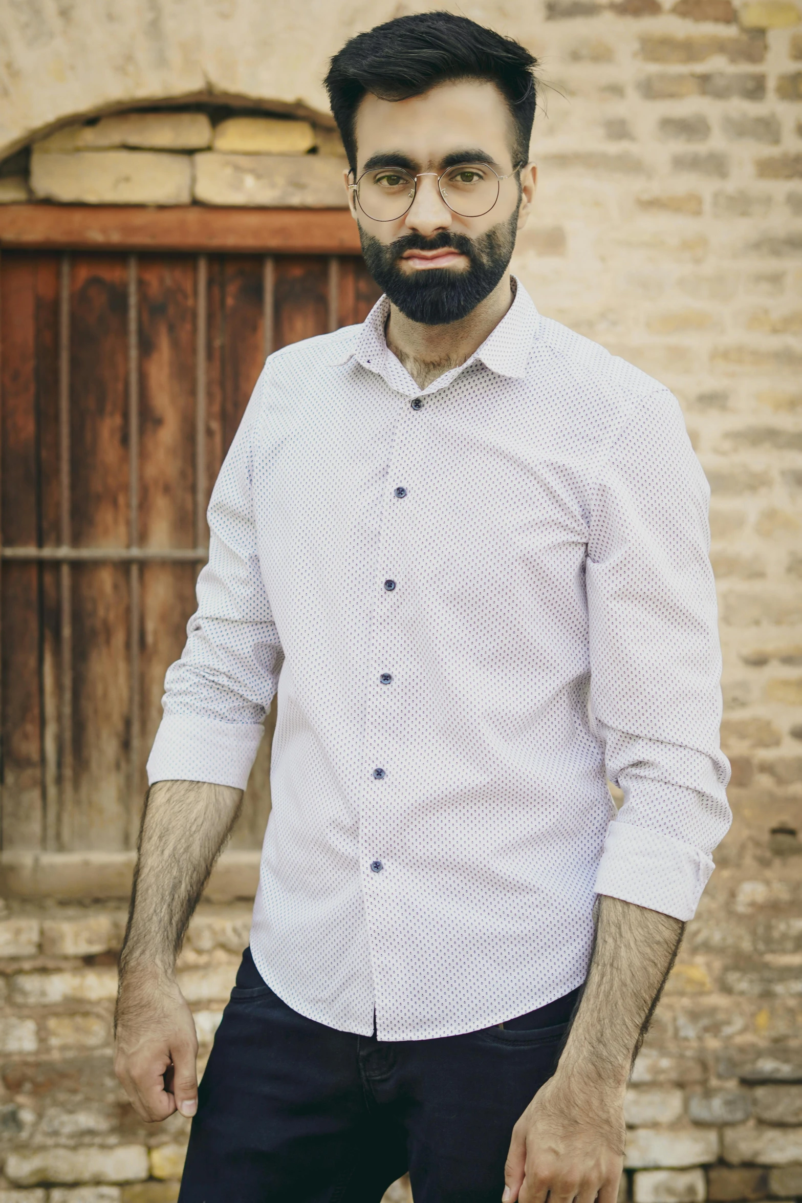 a man standing by a brick wall and looking at soing