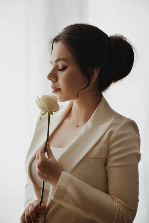 a woman is holding onto a white rose