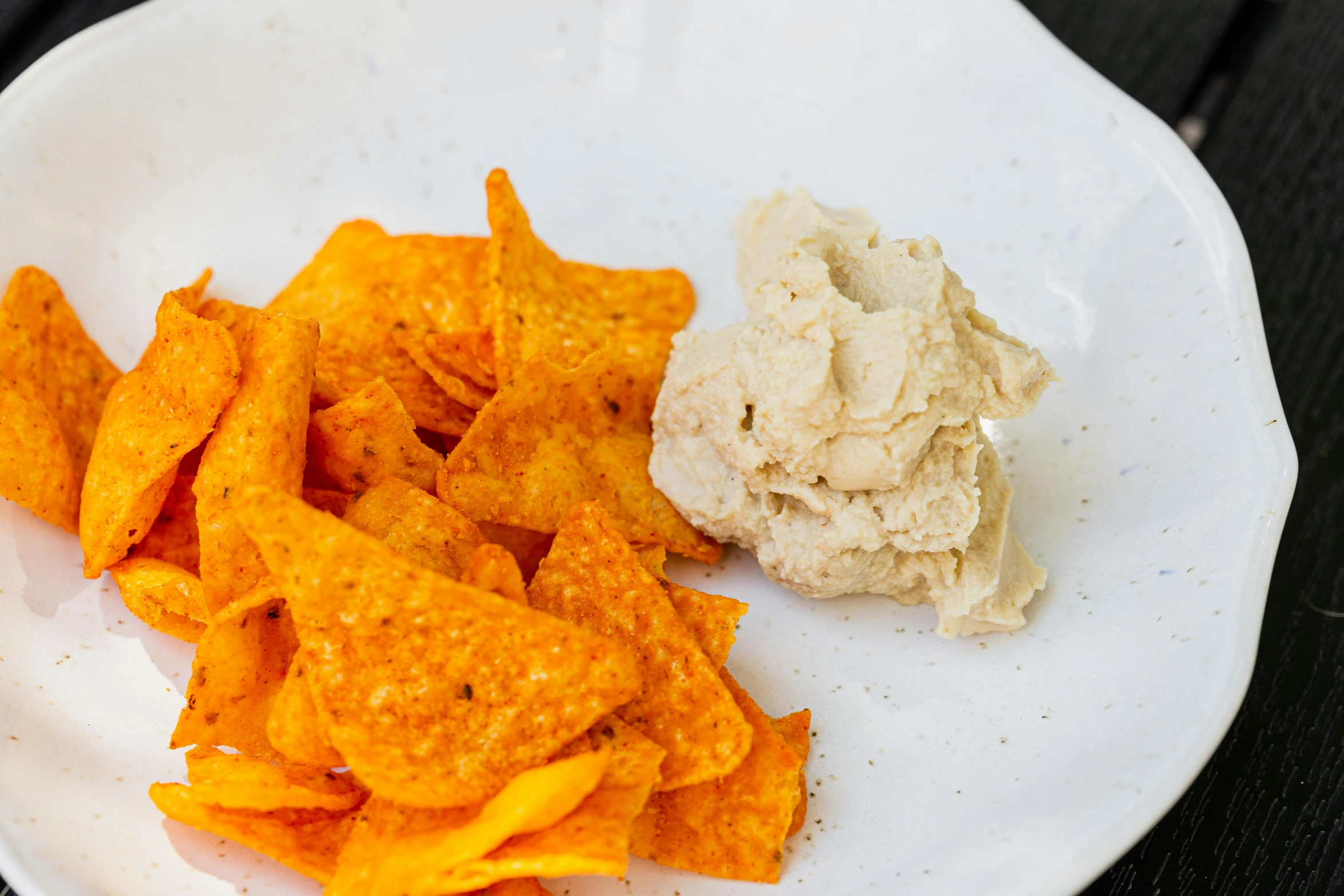 a plate with a scoop of dip and chips